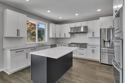 Kitchen of a completed home, island and stainless appliances