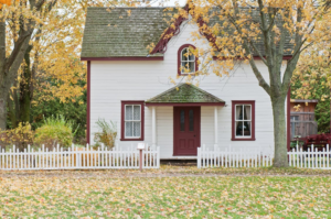 a small backyard house with a white fence